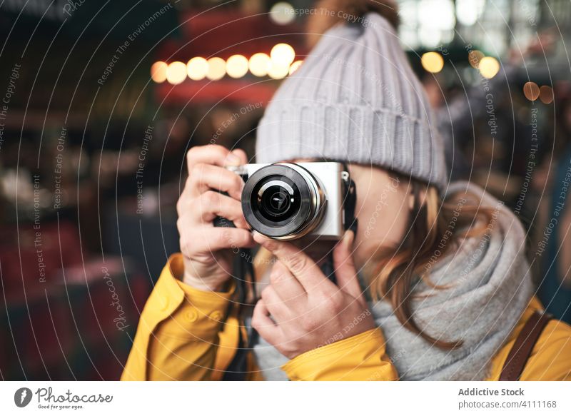 Frau nimmt Foto mit Kamera in der Stadt auf Fotokamera Großstadt Fotografie reisen Winter Abend fotografieren Straße lässig Tourismus warme Kleidung Hobby
