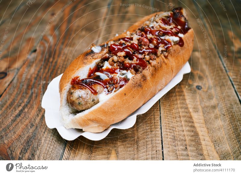Leckerer Hotdog auf Holztisch Wurstwaren geschmackvoll appetitlich Fastfood lecker Mahlzeit Tradition Ketchup hölzern Saucen Tisch Ernährung Feinschmecker Koch
