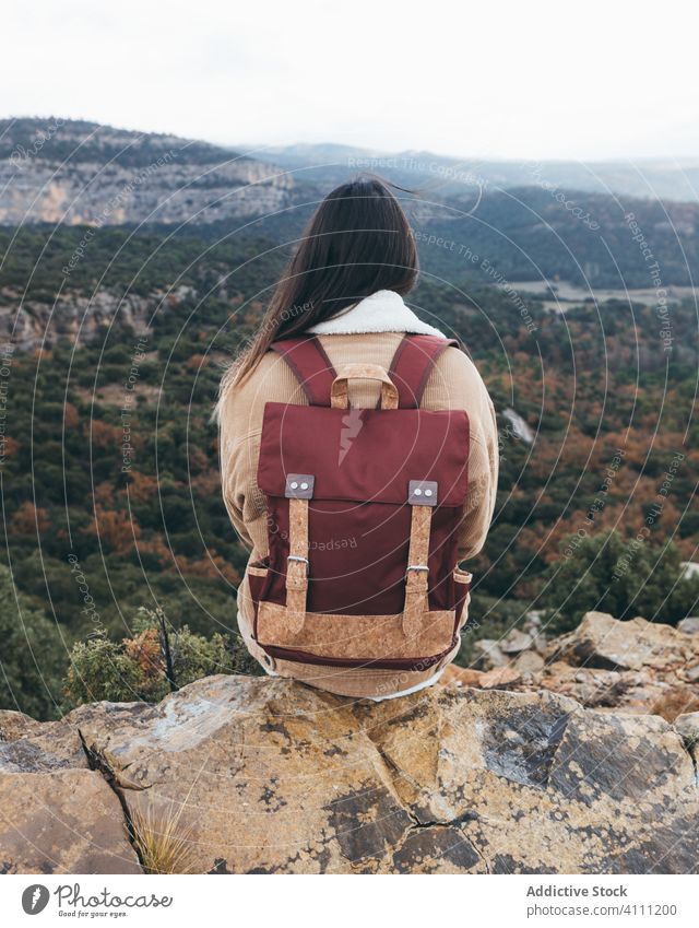 Weiblicher Reisender sitzt auf einem Felsen und genießt die Landschaft Frau reisen Rucksack Hügel Natur Herbst Wald Berge u. Gebirge Abenteuer Wanderung