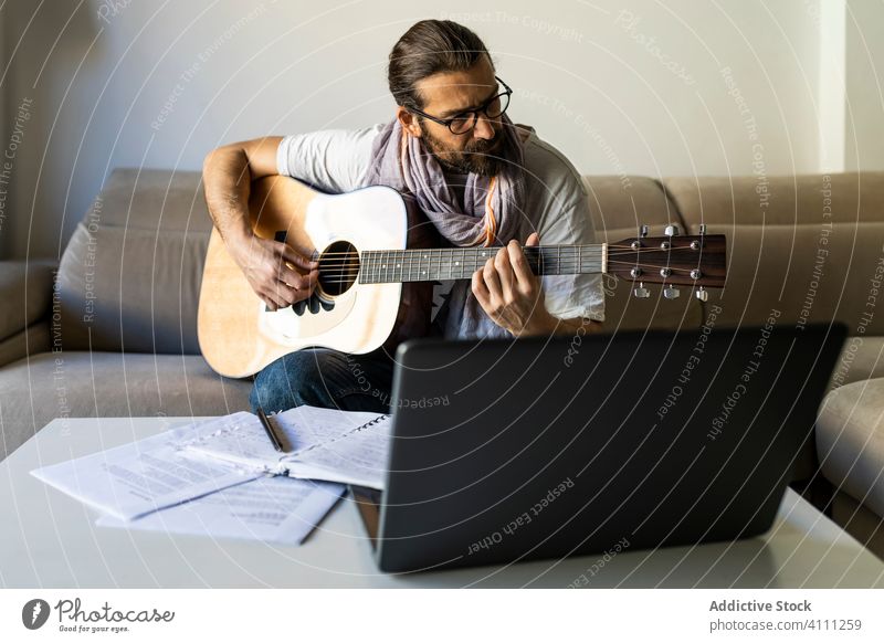 Stilvoller Gitarrist auf der Couch im Wohnzimmer Mann spielen Gitarre sitzen Liege Sofa männlich lässig Musik Songwriter Komponist Dichter heimwärts Lifestyle