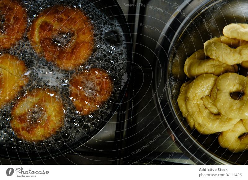Leckere Donuts in heißem Öl frittiert Krapfen braten Erdöl Herd Schaumblase Koch Abschäumer Küche Lebensmittel frisch lecker geschmackvoll Mahlzeit