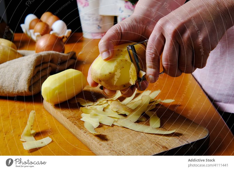 Unbekannter Koch beim Kartoffelschälen in der Küche Küchenchef sich[Akk] schälen Hand Lebensmittel frisch gelb organisch Gesundheit hölzern natürlich Tisch