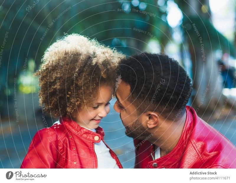 Glückliches kleines Mädchen umarmt Papa im Park Vater Tochter Umarmung Zusammensein Lächeln Straße Liebe ähnlich urban Kind Mann ethnisch wenig Partnerschaft