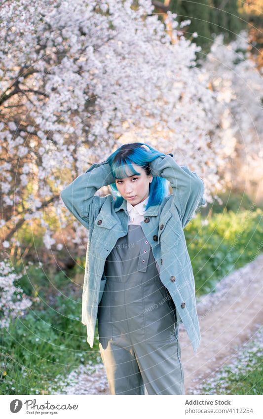Trendige Frau im blühenden Garten Frühling Blütezeit Teenager gefärbtes Haar Blume Stil trendy modern jung blaue Haare Baum Natur geblümt schön Saison frisch