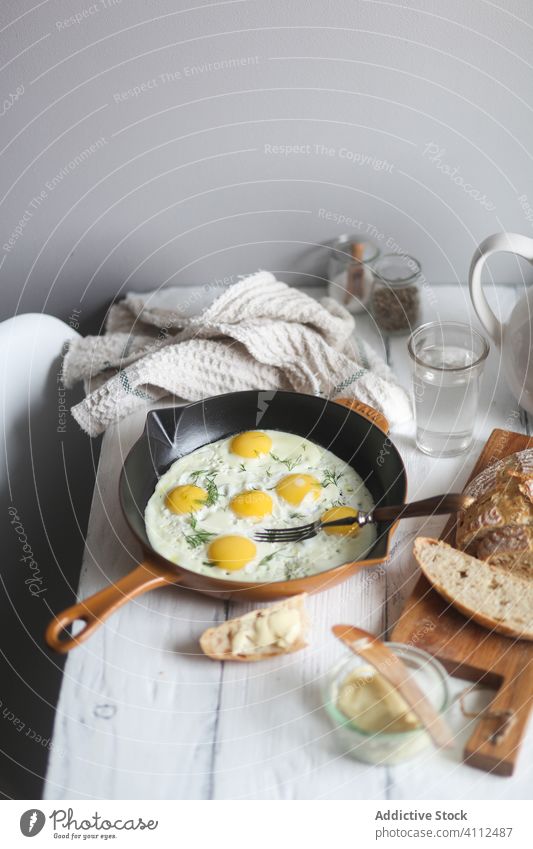 Einfaches Frühstück mit Spiegeleiern und Brot braten rustikal einfach selbstgemacht Pfanne Lebensmittel Tisch hölzern Mahlzeit Küche frisch geschmackvoll Koch