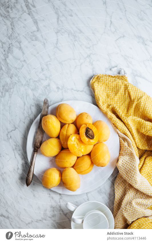 Teller mit frischen Aprikosen auf weißem Marmortisch Frucht reif Tisch gelb orange natürlich Lebensmittel lecker geschmackvoll Gesundheit organisch Bestandteil