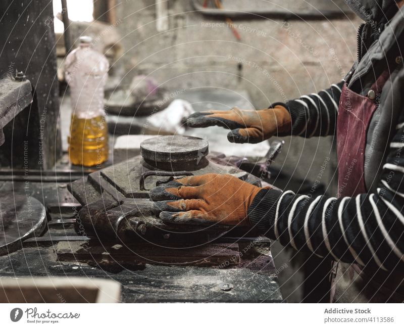 Unbekannter Mann arbeitet mit Metallkonstruktionen und stellt Fliesen her Meister Kunstgewerbler Fliesen u. Kacheln Gerät Maschine Werkstatt Fabrik Hand