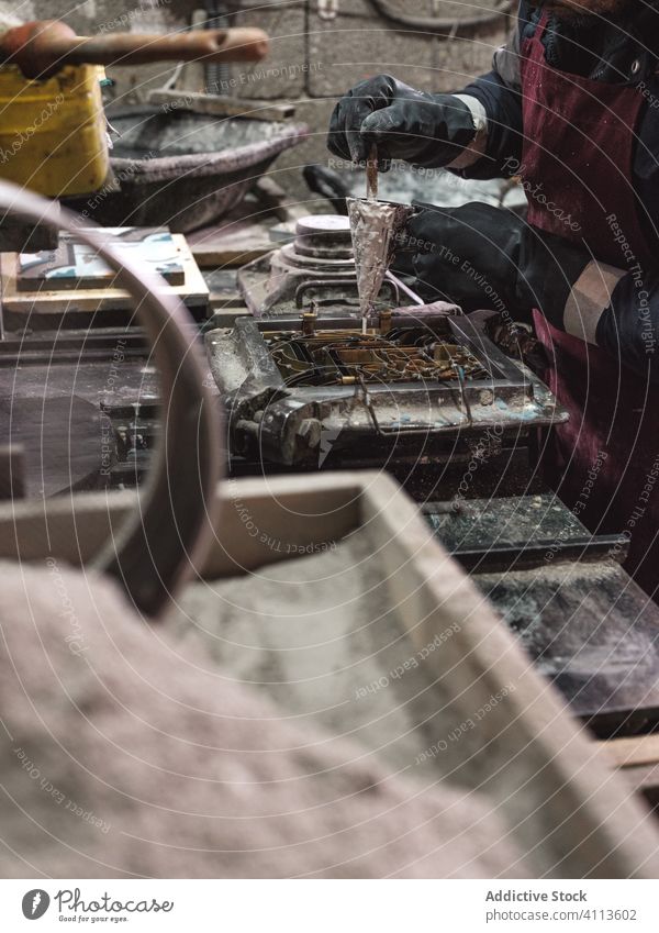 Anonymer Kunsthandwerker gießt flüssiges Material in eine Fliesenschablone Werkstatt Fliesen u. Kacheln manuell Schablone eingießen Herstellung Kleinunternehmen