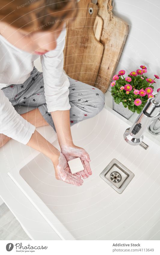 Blondes Kind wäscht sich die Hände in der Küchenspüle, um eine Infektion zu vermeiden Waschbecken Lifestyle Wäsche waschen im Innenbereich Sohn Junge Wasser
