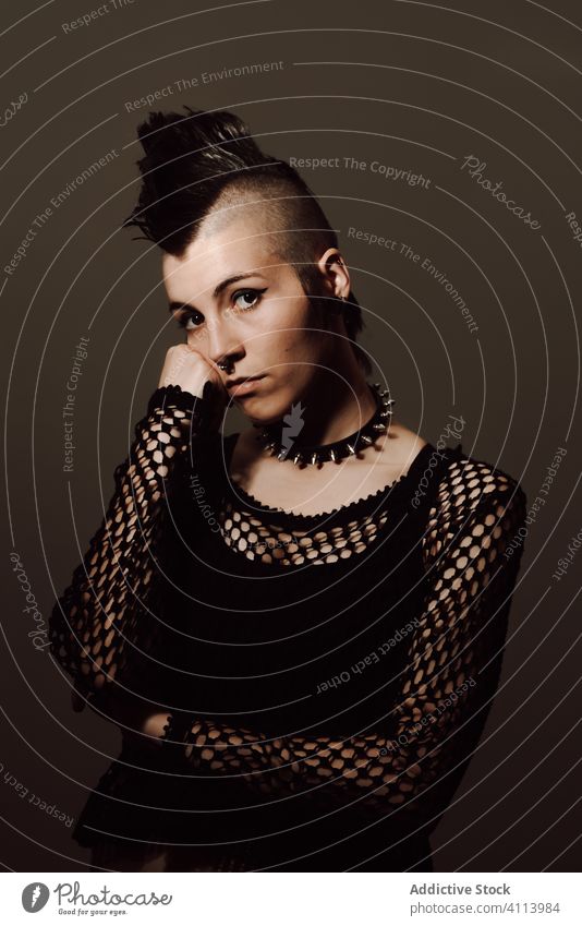 Selbstbewusster weiblicher Punk schaut in die Kamera Frau Stil selbstbewusst Subkultur modern auflehnen mohawk Vorschein dunkel Model Piercing Individualität