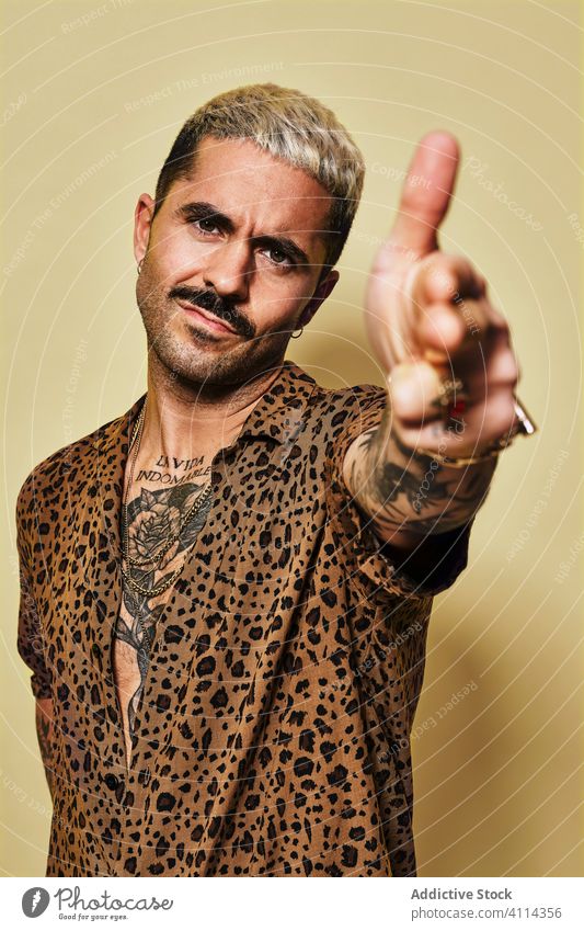 Selbstbewusster, stilvoller Mann im Leopardenhemd trendy Stil selbstbewusst schießen gestikulieren Mode Fingerpistole Model Vollbart männlich ethnisch Stoff