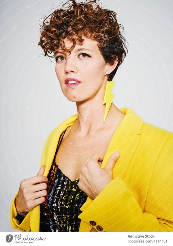 Glückliche Frau in trendigem Outfit Stil Lächeln Porträt Pailletten-Top modern urban ausrichten Mantel Blitze Ohrringe Model gelb Farbe hell heiter trendy