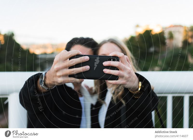 Glückliches multiethnisches Paar macht Selfie in der Stadt Smartphone Großstadt Zusammensein Brücke jung Straße urban Lifestyle Gerät Apparatur Mobile