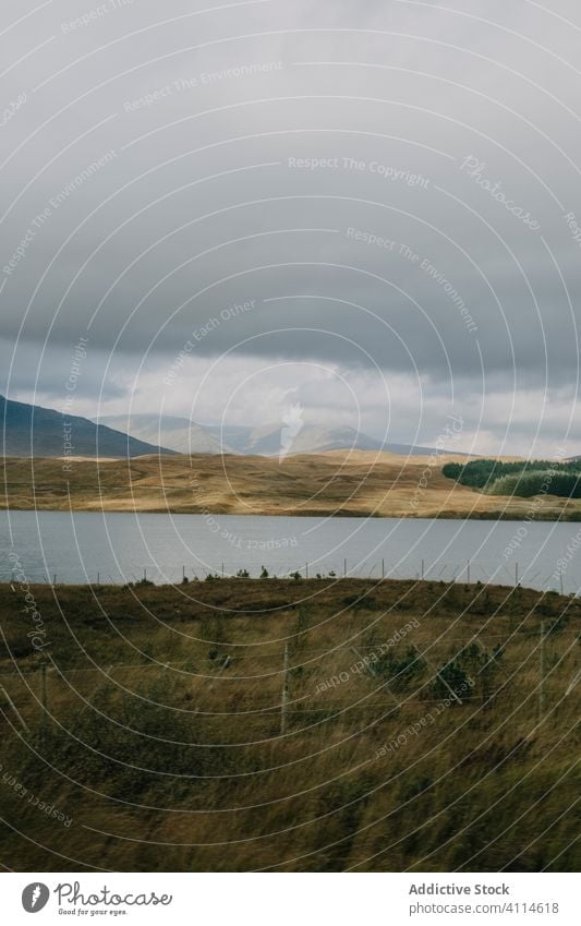 Herbstlandschaft mit See und bewölktem Himmel wolkig bedeckt Hochland Hügel trist grau Windstille ruhig Schottland Natur Landschaft reisen Berge u. Gebirge