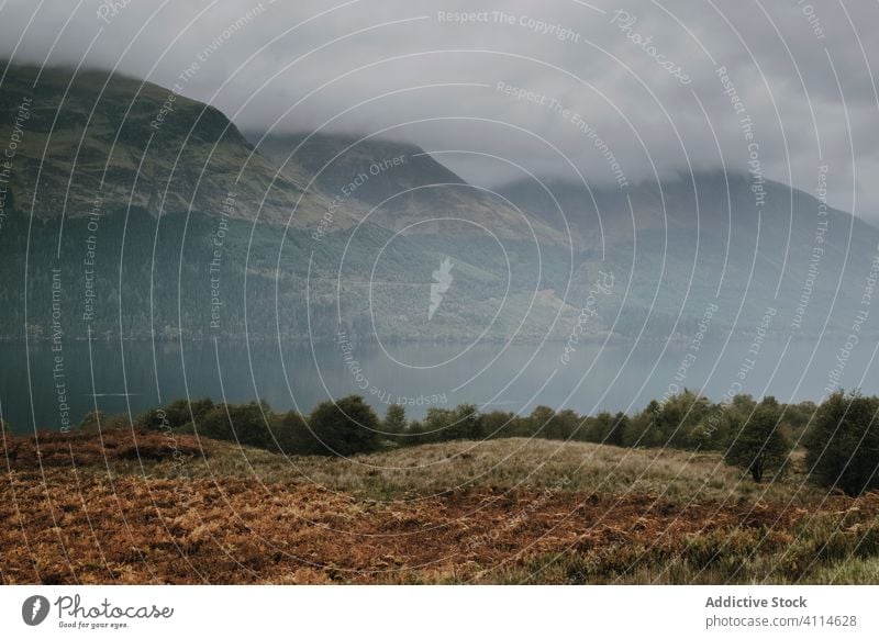 Neblige Landschaft mit Bergen und See Berge u. Gebirge Nebel Cloud Felsen Hochland Ambitus Windstille ruhig Wasser Natur kalt friedlich Schottland trist Ufer