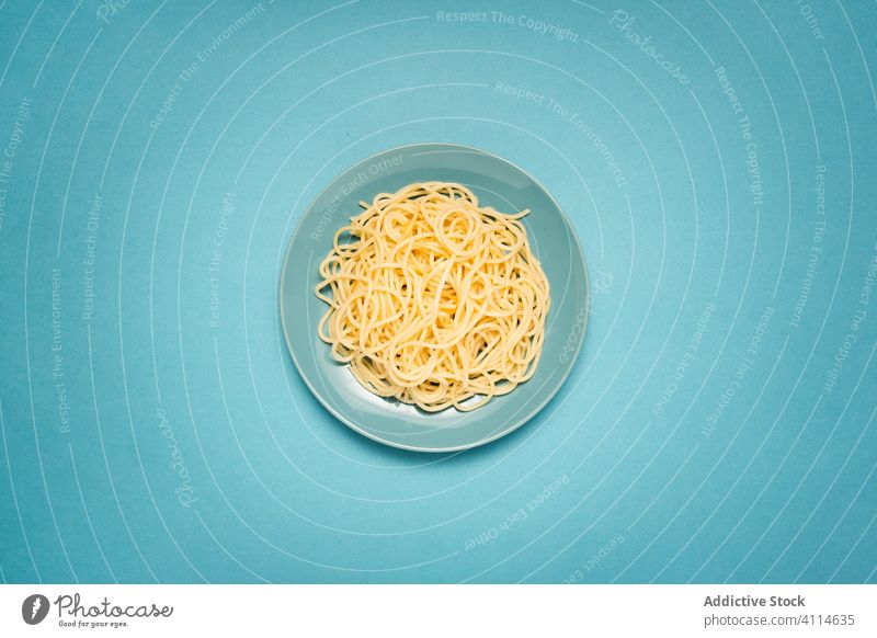 Leckere Spaghetti auf blauem Hintergrund lecker Keramik Italienisch einfach Ebene Haufen gekocht hölzern Tisch Teller Spätzle geschmackvoll Gesundheit