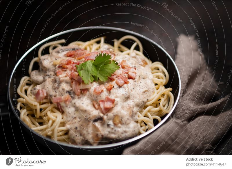 Draufsicht auf appetitliche Nudeln mit Schinken und Pilzen in Sahnesoße, serviert in der Pfanne Spätzle Saucen geschmackvoll Spaghetti Schneidebrett Gesundheit