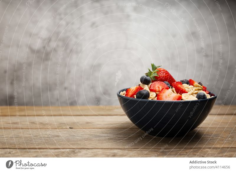 Frische Cornflakes mit Erdbeeren und Blaubeeren auf dem Holztisch Frühstück Müsli lecker Tisch frisch Schalen & Schüsseln organisch Gesundheit Ernährung Beeren