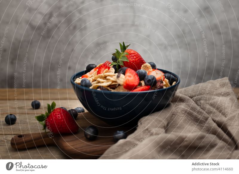 Frische Cornflakes mit Erdbeeren und Blaubeeren auf dem Holztisch Frühstück Müsli lecker Tisch frisch Schalen & Schüsseln organisch Gesundheit Ernährung Beeren