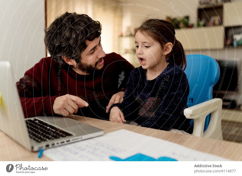 Vater hilft Tochter bei Fernstudium abgelegen lernen Laptop heimwärts Hilfsbereitschaft Bildung Zusammensein Partnerschaft Mann Mädchen Kind Eltern sitzen