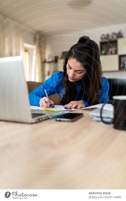 Weibliche Freiberuflerin, die zu Hause arbeitet Frau freiberuflich heimwärts schreiben Hinweis Papier Fokus Arbeit Projekt abgelegen Laptop Tisch Job gemütlich