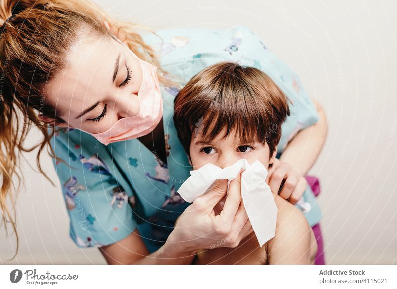 Kleiner Junge schnäuzt sich im Krankenhaus bei einer Untersuchung Kind krank Schlag Nase Bett geduldig Atemwegserkrankungen Frau Krankenpfleger Gesundheitswesen