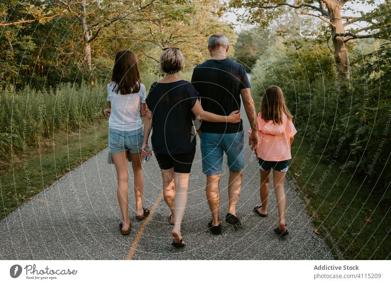 Glückliche Familie beim Spaziergang in der Natur an einem Sommertag Zusammensein Park Wald Landschaft Weg aktiv lässig grün Liebe Partnerschaft Lifestyle Baum