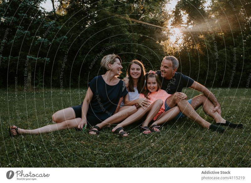 Glückliche Familie ruht sich auf der grünen Wiese aus Zusammensein Natur ruhen sich[Akk] entspannen sitzen Park Wald Landschaft Sommer Lächeln aktiv lässig Gras