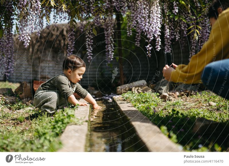 Mutter fotografiert Kind spielt mit Wasser Mutter mit Kind 1-3 Jahre Kaukasier Farbe Spielen Neugier unschuldig erkunden niedlich Frau Liebe Lifestyle