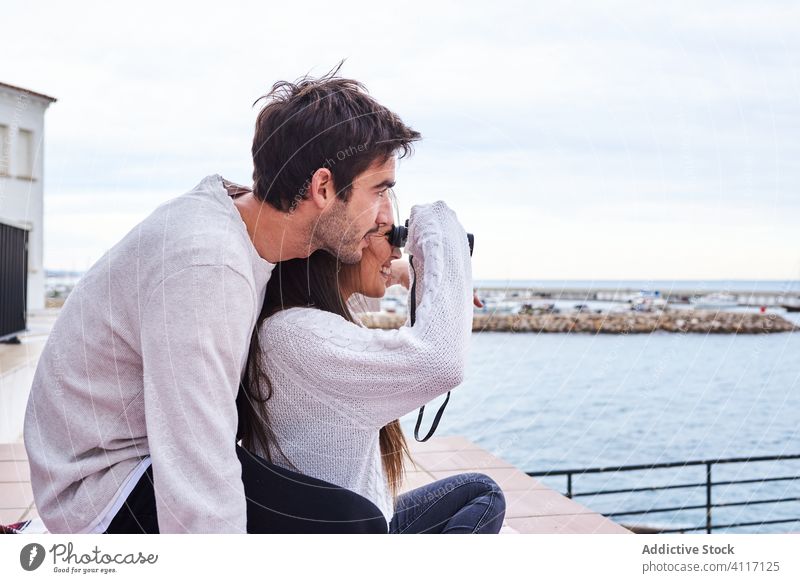 Glückliches junges Paar mit Fernglas, das sich am Meer ausruht Terrasse Seeküste heiter romantisch genießen Feiertag lässig Zusammensein Urlaub Liebe reisen