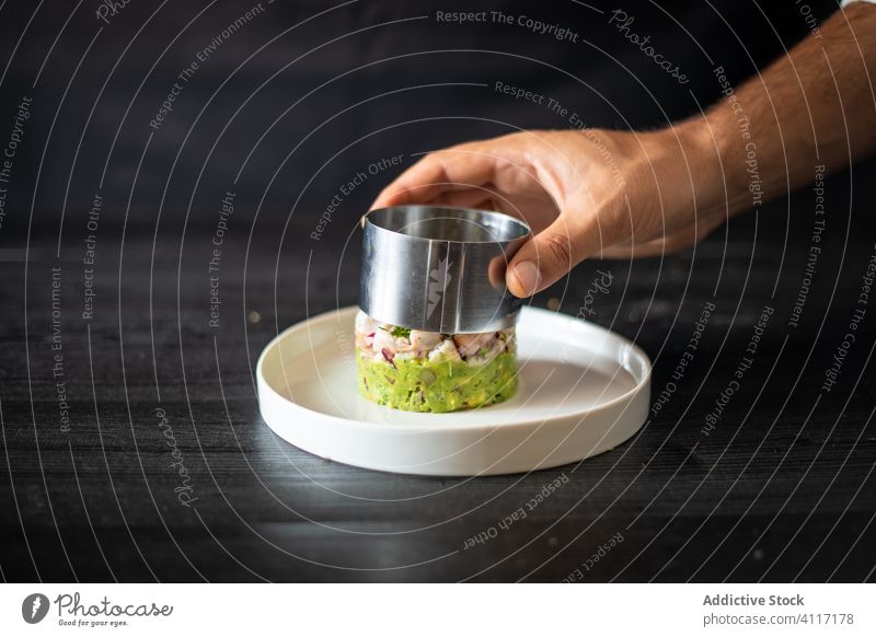 Crop Cook formt leckeren Salat auf dem Teller Küchenchef Salatbeilage Koch Restaurant Haute Cuisine Formular Ring Tisch Gesundheit geschmackvoll Metall Keramik