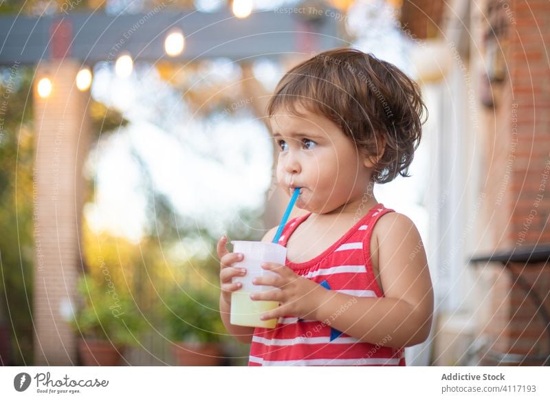 Niedliches Kleinkind trinkt frischen Saft aus einem Strohhalm trinken Sommer ruhen stehen Kind Getränk sich[Akk] entspannen bezaubernd niedlich Wasser Urlaub