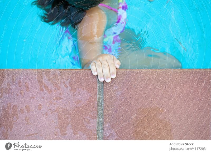 Kind beim Schwimmen am Beckenrand schwimmen Pool Wasser packen Borte ruhen Resort Sauberkeit Sommer sich[Akk] entspannen Freude Wochenende Lifestyle Urlaub nass