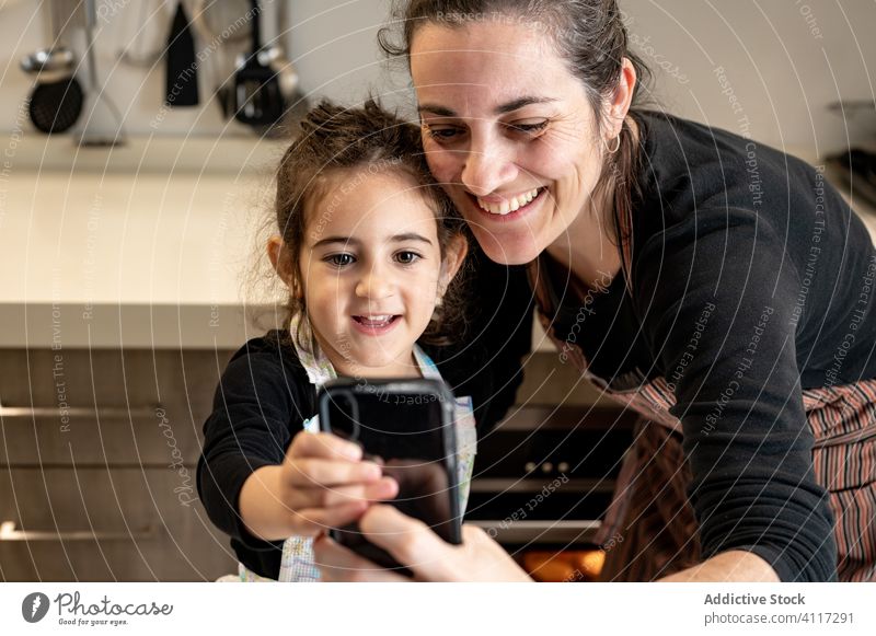 Mutter macht Selfie mit Kind bei der Zubereitung von Gebäck Kinder Koch heimwärts Küche Smartphone Handy Lächeln Glück Liebe Zusammensein gemütlich Mädchen Frau