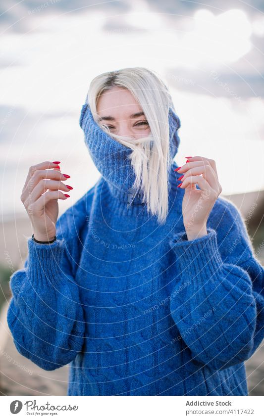 Fröhliche junge Frau im warmen Pullover blau Glück MEER Lachen positiv blond Freude Natur heiter Stil warme Kleidung gestrickt tausendjährig Feiertag charmant