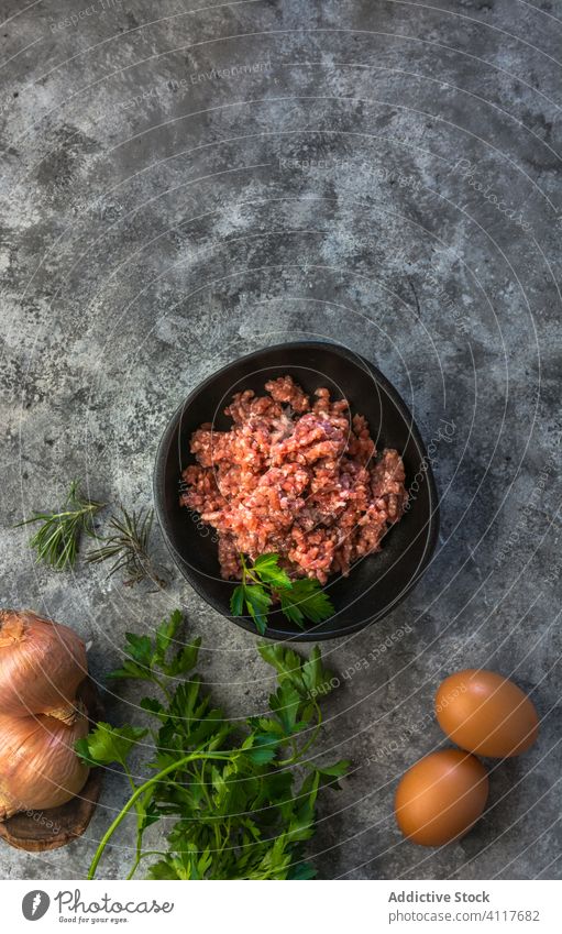 Kräuter, Eier und Zwiebeln neben Hackfleisch Fleisch zerkleinern Kraut Tisch Küche rustikal Salz frisch Lebensmittel Bestandteil Feinschmecker Ernährung