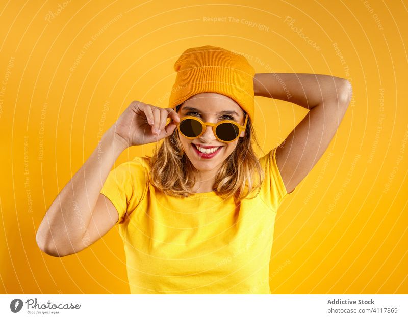 Positive Frau auf buntem Hintergrund modern positiv Sonnenbrille Stil hell trendy Mode heiter Accessoire Glück Hipster pulsierend Lächeln lebhaft Zeitgenosse
