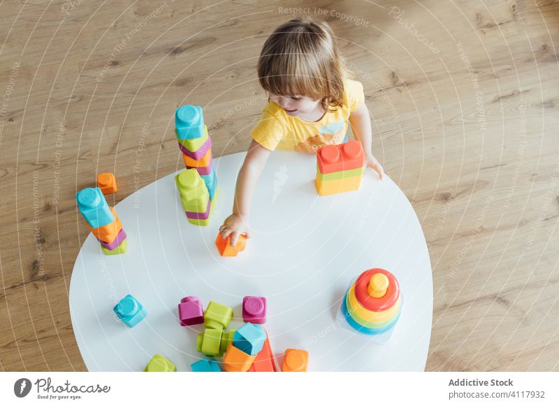 Kleines Kind spielt mit buntem Spielzeug spielen Pyramiden bauen Klotz Stapel Vorschule farbenfroh Säugling Mädchen entwickeln wenig Bildung Kindergarten Baby
