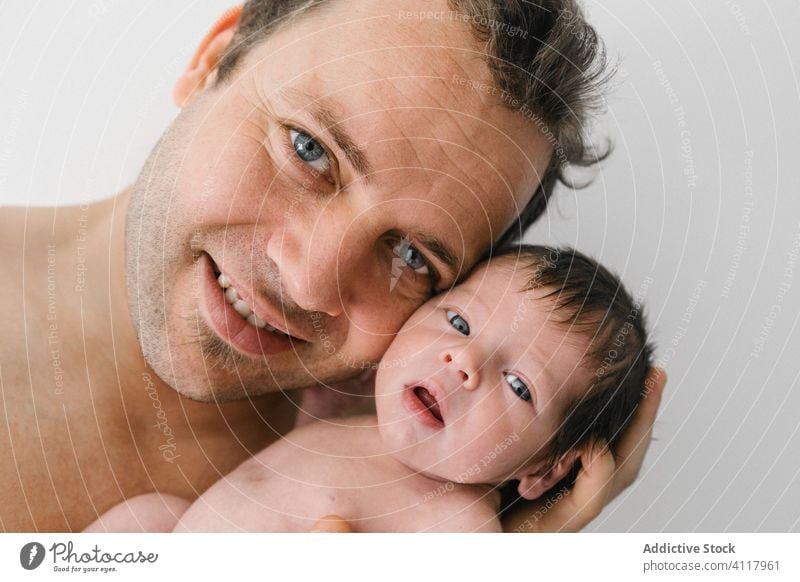 Glücklicher Vater mit kleinem Baby neugeboren Mann Liebe Eltern Umarmen kuscheln Porträt heiter männlich Kind Umarmung Lächeln Papa Zusammensein süß wenig