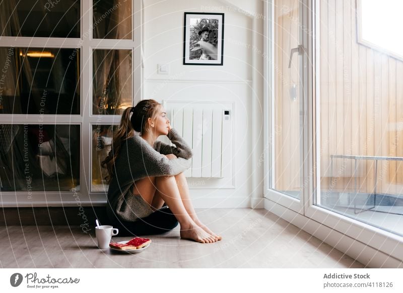 Verträumte Frau beim Frühstück am Fenster zu Hause heimwärts träumen besinnlich Stock Zuprosten Kaffee lässig sich[Akk] entspannen Morgen allein sitzen jung