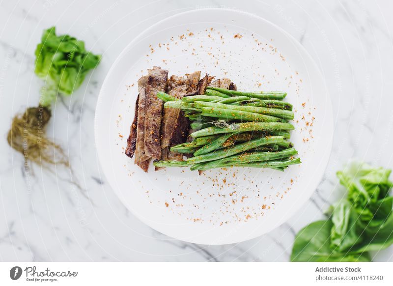 Steak und grüne Bohnen auf dem Teller Salatbeilage Gewürz Fleisch Gemüse gesunde Ernährung Abendessen Haufen Ordnung Grün Portion Feinschmecker natürlich Diät