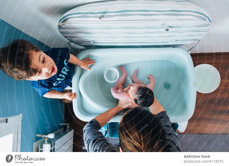 Mutter mit kleinem Sohn wäscht Baby in der Badewanne Frau Kinder Die Geschwister Pflege neugeboren Waschen ethnisch Schalen & Schüsseln Liebe sanft Zusammensein