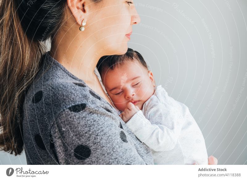 Glückliche ethnische Mutter mit Baby im Arm Frau Liebe neugeboren Eltern Pflege vorsichtig niedlich Umarmung Zusammensein Kind Anzug Kindheit heimwärts