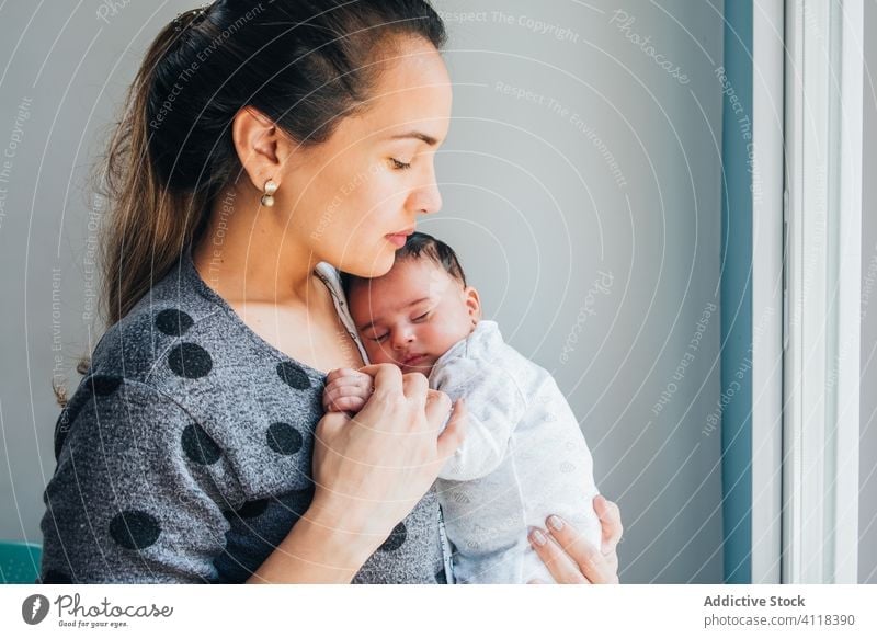 Glückliche ethnische Mutter mit Baby im Arm Frau Liebe neugeboren Eltern Pflege vorsichtig niedlich Umarmung Zusammensein Kind Anzug Kindheit heimwärts