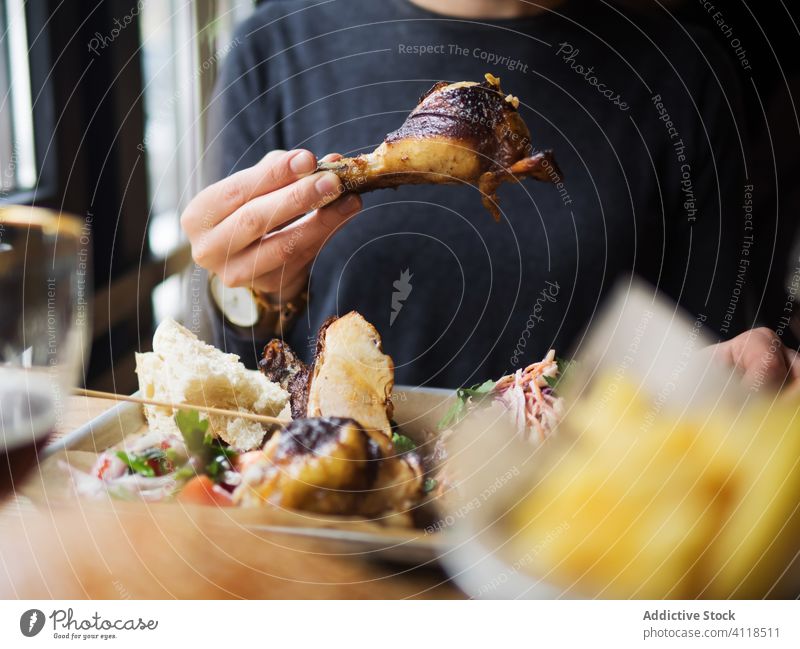 Mann isst gegrillte Hühnerkeule im Restaurant Fastfood Hähnchen Trommelschlegel Grillrost essen Café dienen Tisch Mittagessen Mahlzeit Speise Ernährung Braten