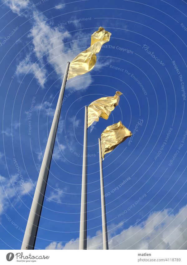 Goldene Fahne Flagge Mast golden wehen Himmel Wolken Wind Fahnenmast Außenaufnahme flattern Menschenleer