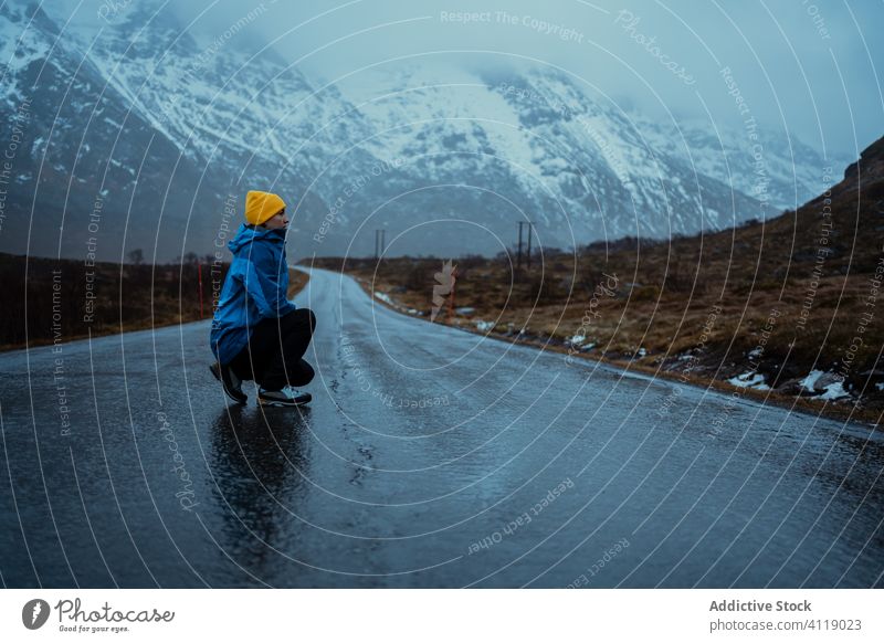 Einsamer erwachsener Tourist genießt Ruhe und frische Luft auf leerer Straße im nebligen Hochland im Winter Frau geduckt Freiheit Berge u. Gebirge Tourismus