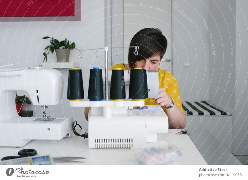 Fröhliche Näherin, die zu Hause arbeitet Frau nähen Nähmaschine heimwärts Werkstatt Kleidungsstück Arbeit Erwachsener Prozess Schneider Kunstgewerbler