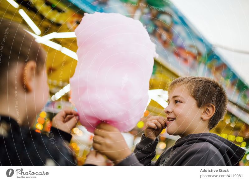 Kinder essen Zuckerwatte auf dem Rummelplatz Jahrmarkt Lächeln Lichter Großstadt Fairness Entertainment Glück urban süß Spaß erfreut Leckerbissen Junge
