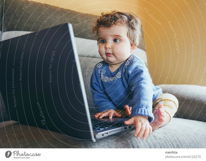 Kleines Baby zu Hause spielen mit einem Laptop Technik & Technologie heimwärts Verlauf Zukunft Sofa Möbel pc Computer Risiko WiFi soziale Netzwerke neu